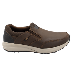 The Florsheim Excursion Slip On features a smooth brown leather upper, dark fabric around the heel, superb shock absorption, visible stitching, a black grip detail at the back, a branded tag, and a light-colored sole.