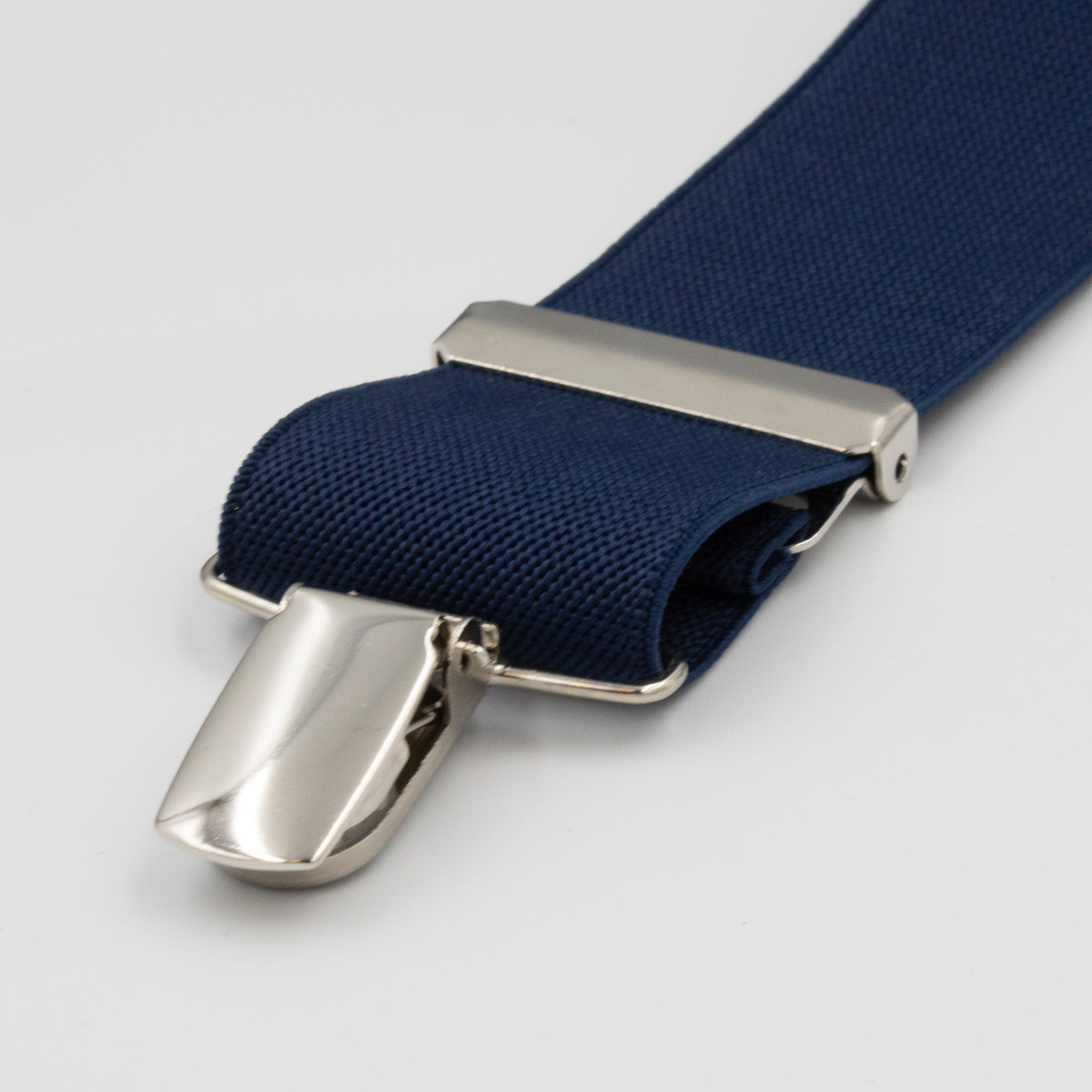 Close-up of Buckle Plain Braces featuring an adjustable blue elastic strap with a shiny, high-quality metal clip attached, looped through a silver buckle against a plain white background.