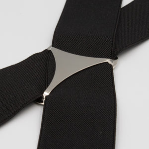 Close-up of Buckle Plain Braces featuring a silver triangle-shaped connector in the center and high-quality clasps, set against a white background. The black adjustable straps exhibit a textured appearance.