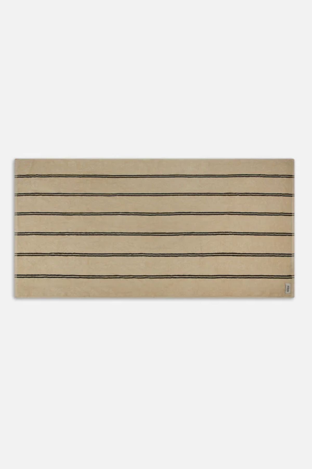 The Industrie The Comporta Beach Towel, a rectangular beige towel with evenly spaced thin black horizontal lines in a halo stripe design, is displayed on a plain white background.