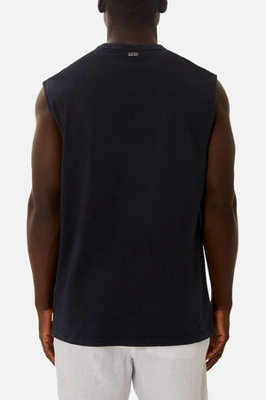 A man is seen from the back wearing an oversized Industrie The Del Sur Sleeveless Tee and light gray shorts, standing against a plain white backdrop.