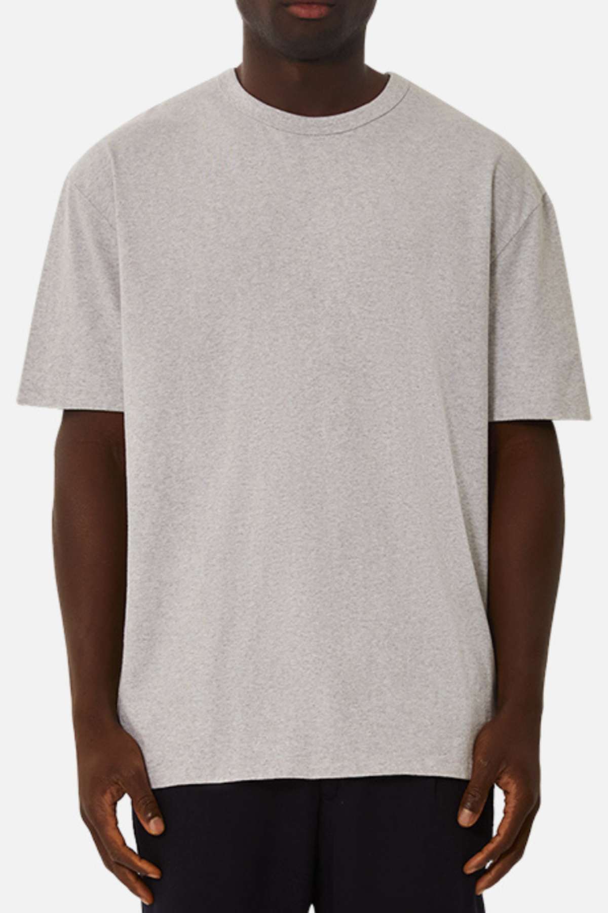 A person stands facing forward against a white background, wearing the Industrie The Del Sur Tee in light gray with dark pants. Their arms are relaxed by their sides.