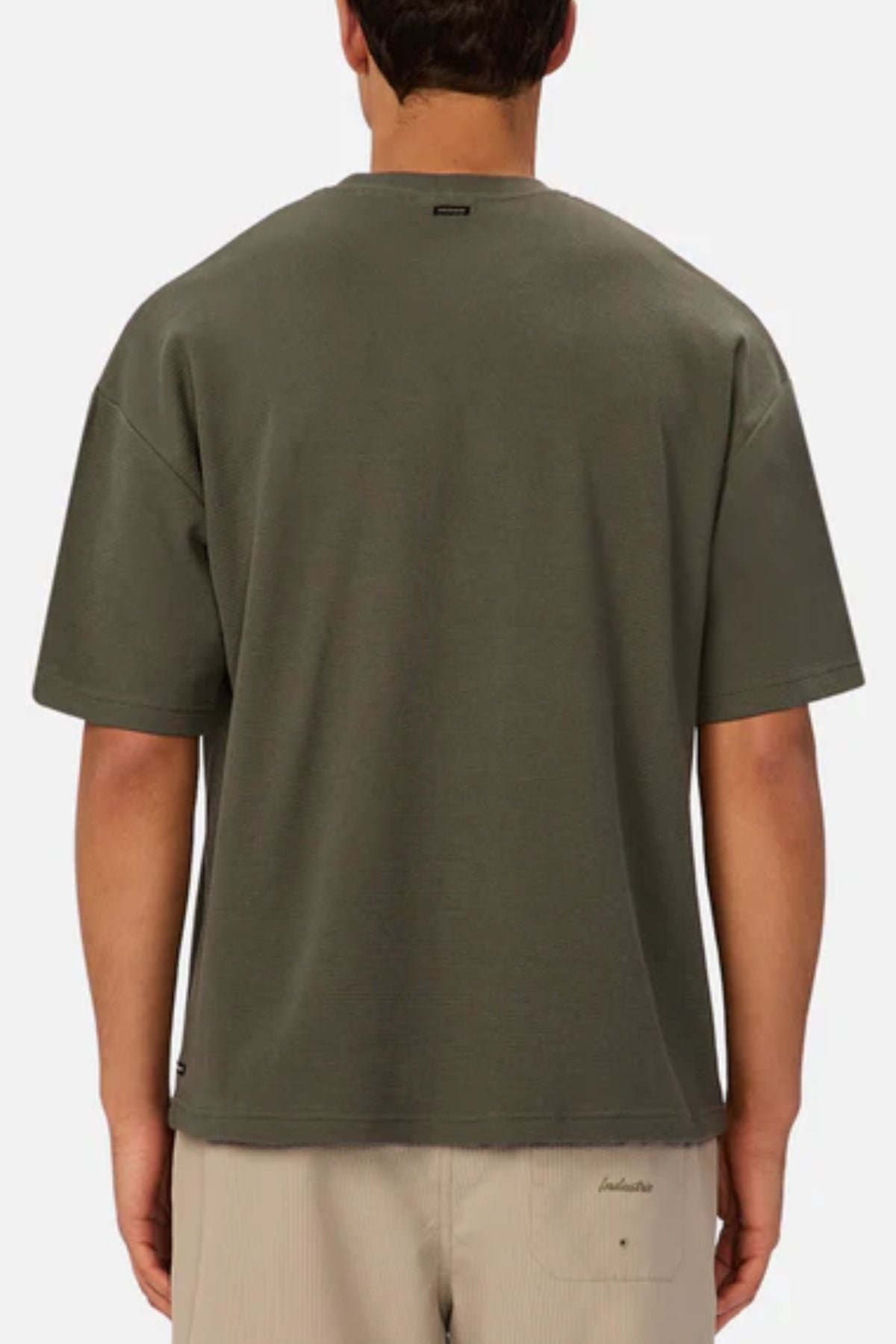 A person is seen from the back wearing the Industrie The Marlon Tee in olive green with light beige shorts, perfect for casual wear, against a plain light background.