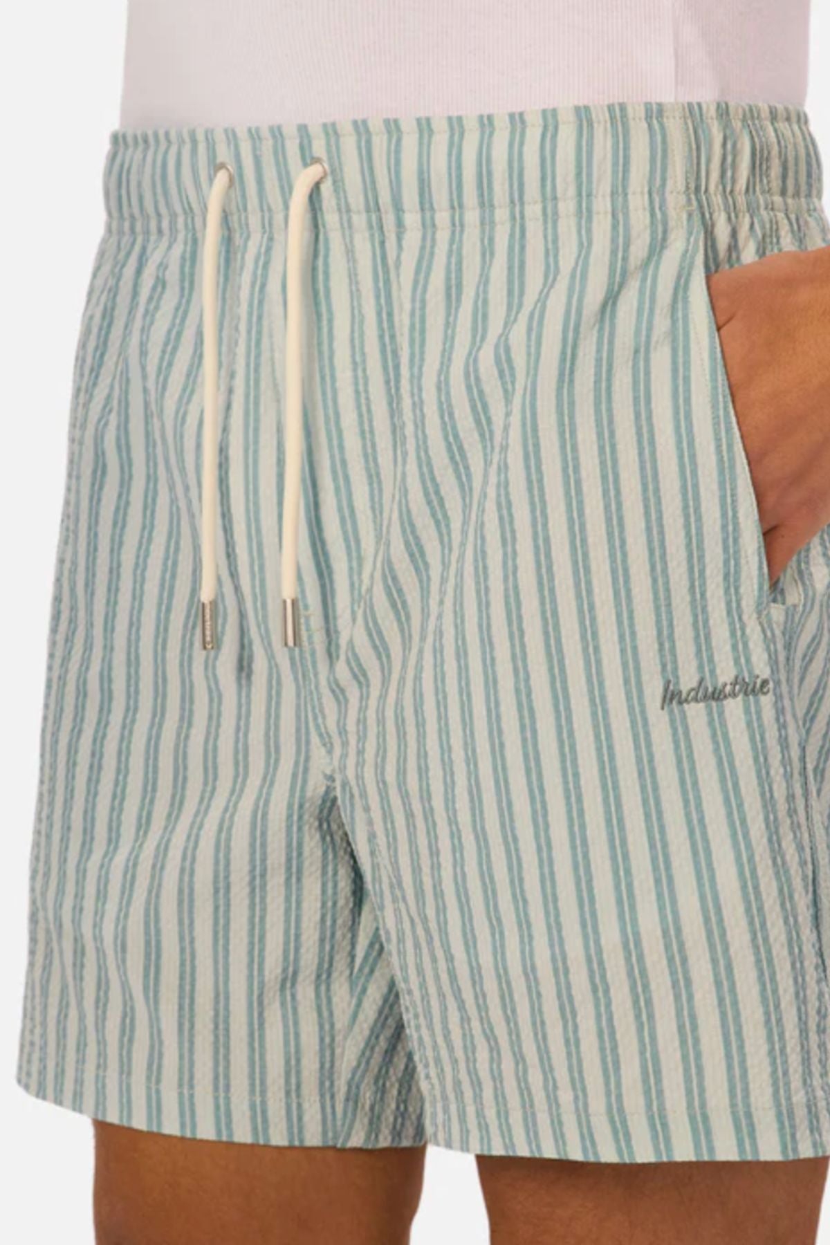 A person wears the Industrie The Berkeley Swim Short in light blue and white stripes with a white drawstring, right hand in pocket, and "Industrie" embroidered on the left thigh, showcasing these must-have quick-dry men's swim shorts.