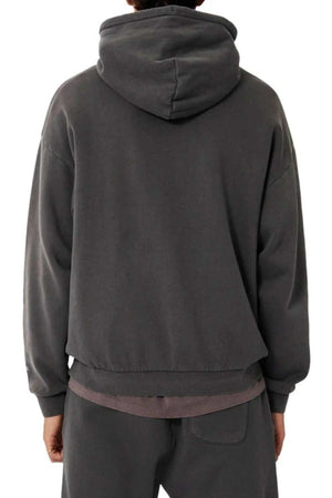 A person is seen from the back wearing an oversized fit, dark gray Industrie The Del Sur Hoodie with matching sweatpants. The hood is up and their hands rest by their sides against a plain white background.