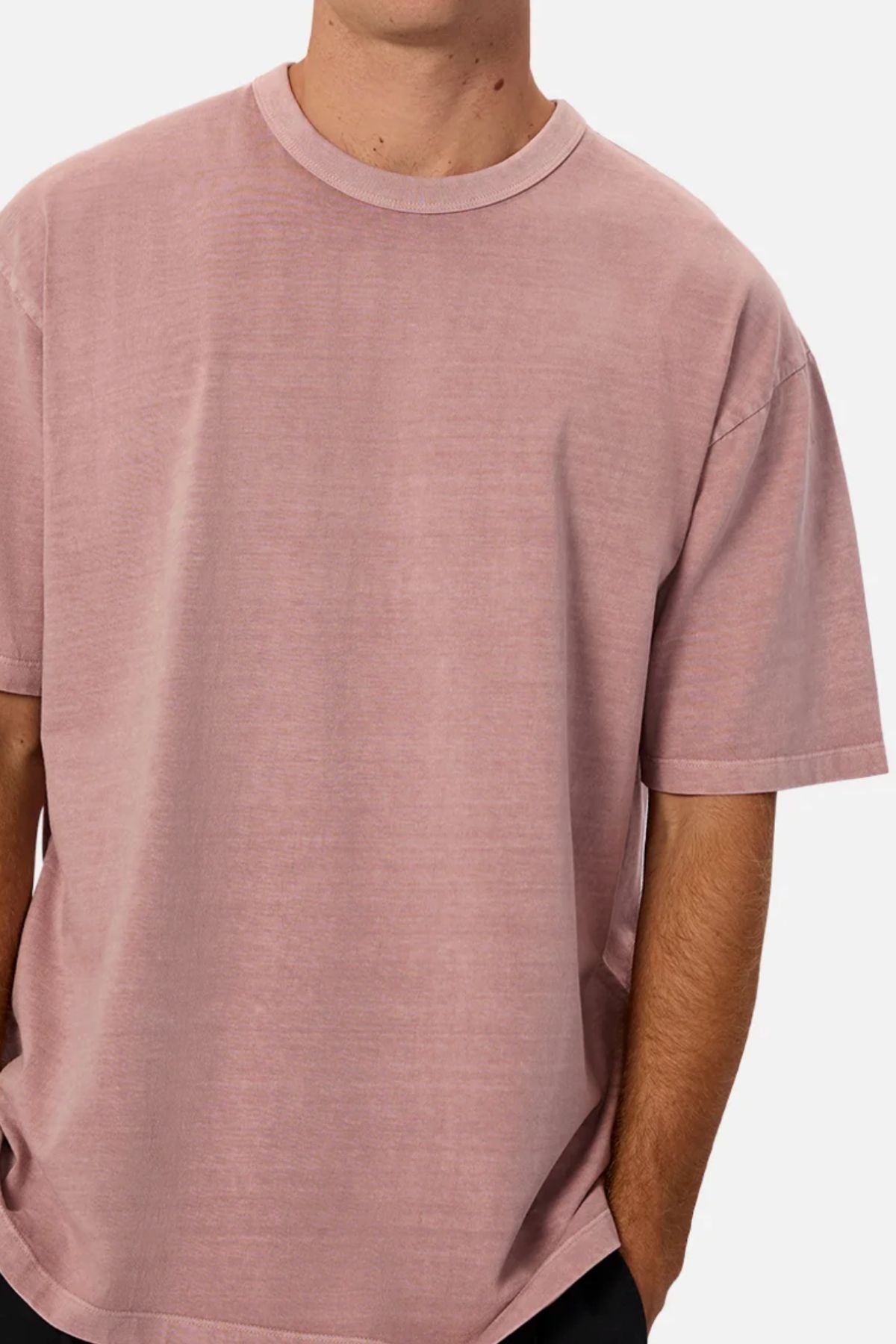 Wearing the Industrie The Del Sur Tee in dusty pink, a person with their right hand in their pocket is shown from shoulders to mid-torso against a plain light background.