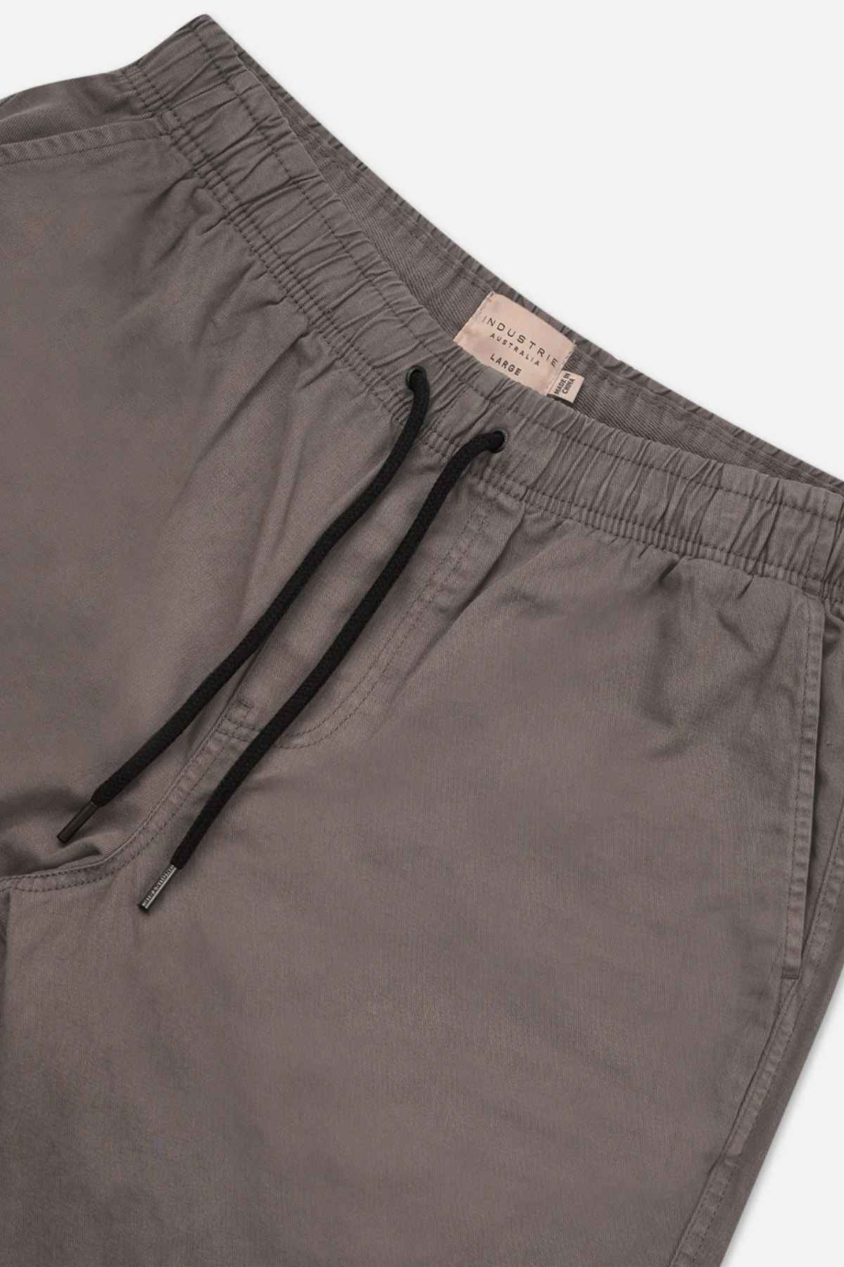Industrie The Dublin Short: Gray jogger-style shorts with an elastic waistband and black drawstring. The soft, slightly wrinkled fabric makes them a summer wardrobe staple. A small beige label is sewn inside the waistband.