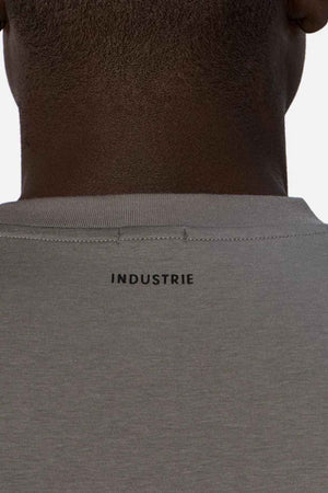 Back view of a person wearing the relaxed-fit Industrie The Freeman Athletic Tee in gray. The iconic "INDUSTRIE" branding prominently adorns the top center of the back, showcased against a plain background.