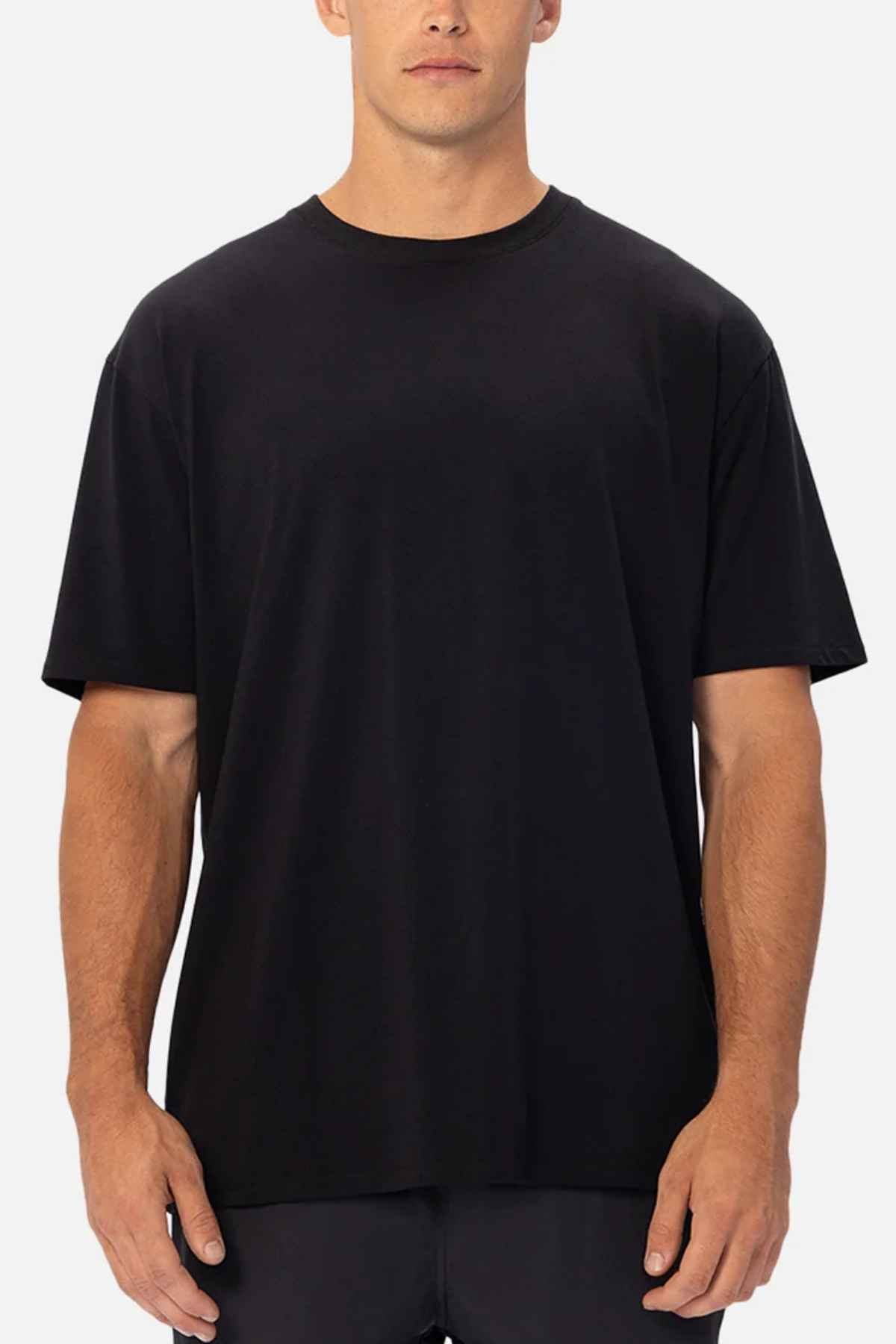 A person wearing the Industrie The Freeman Athletic Tee stands against a neutral background. This relaxed-fit T-shirt boasts a minimalist design with short sleeves and a round neckline, making it lightweight and ideal for everyday use.