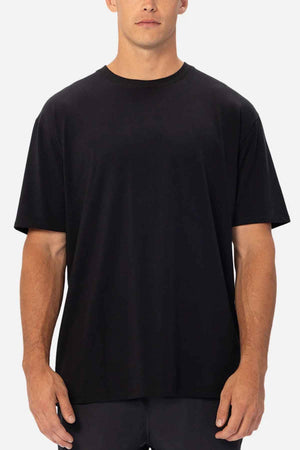 A person wearing the Industrie The Freeman Athletic Tee stands against a neutral background. This relaxed-fit T-shirt boasts a minimalist design with short sleeves and a round neckline, making it lightweight and ideal for everyday use.