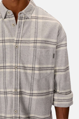 A person wears the stylish Industrie The Gloucester Shirt in light gray plaid with rolled-up sleeves, a chest pocket, and light buttons. Made from 100% cotton, it's presented on a plain white background.