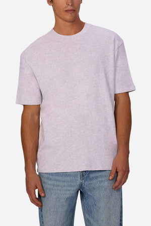 A person wearing the Industrie Henderson Boucle Tee and blue jeans stands against a white background. The oversized look of the light gray t-shirt, crafted from 100% cotton, exudes a casual vibe with its loose fit and short sleeves.