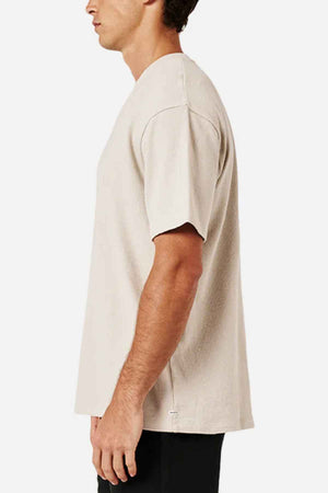 A person wearing an oversized Industrie The Henderson Boucle Tee, made from 100% cotton, stands sideways against a white background.