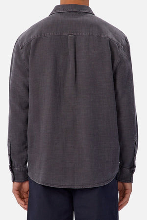 A person is seen from the back wearing the Industrie Lisbon Long Sleeve Shirt, a relaxed fit, dark gray button-up with a classic collar. It’s paired with dark pants and set against a plain, light-colored background.