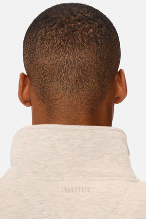 Rear view of a person with short black hair in an Industrie The Luton Track Top in light gray. The quarter zip neck offers a modern look, with "INDUSTRIE" subtly printed on the collar. The soft fleece lining ensures comfort against the crisp white background.