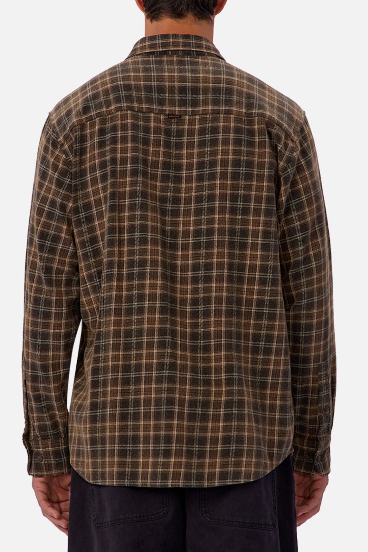 A person stands with their back to the camera wearing the Industrie The Maple Long Sleeve Shirt, which features brown and beige checks, paired with dark pants against a plain background.