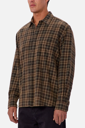 A person wearing the Industrie The Maple Long Sleeve Shirt in brown and green checks with black pants, standing against a plain white background.