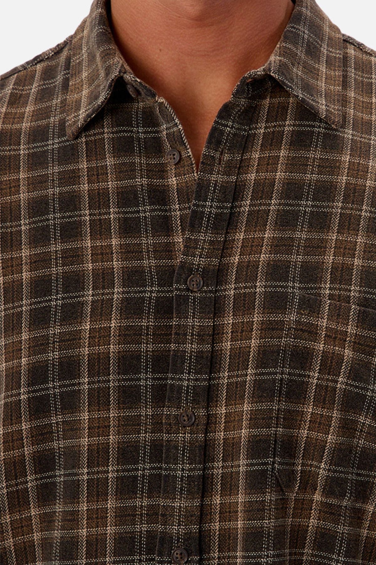 A close-up of a person wearing the Industrie The Maple Long Sleeve Shirt, featuring a brown and black cotton checked pattern, collar, visible buttons, and long sleeves. Only the lower face, neck, and upper torso are shown.