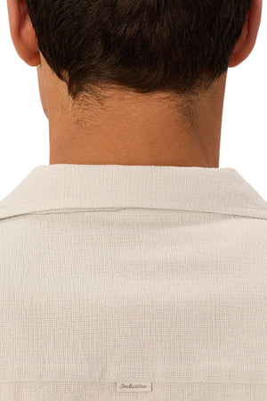 The image shows the back of a person's neck and head with short brown hair, wearing the Industrie The Marbella Short Sleeve Shirt made from lightweight textured fabric, viewed from behind.