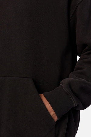 Someone wearing the Industrie The New Del Sur Fleece Hoodie with their right hand in the front pocket. Only part of their torso and arm are visible against a plain background.