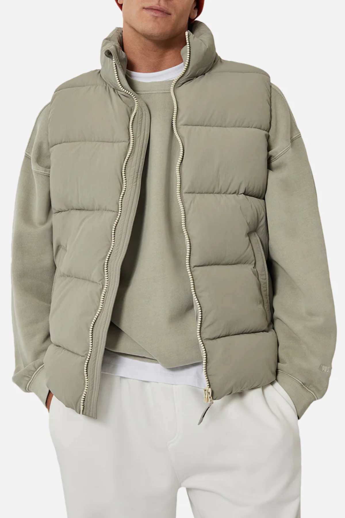 A person wears the Industrie The New Hanam Puffer Vest in light beige over a matching sweatshirt and white pants, creating a casual, relaxed look with hands in their pockets.