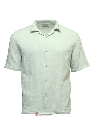 The Industrie The Seguro Short Sleeve Shirt is a light green, textured button-up with a collar and relaxed, loose fit. It features short sleeves and is displayed against a white background.