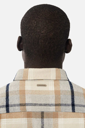Rear view of a person with short hair wearing the Industrie The Somerville Shirt in plaid beige, gray, and blue. A small Industrie tag features on top against a plain white background.