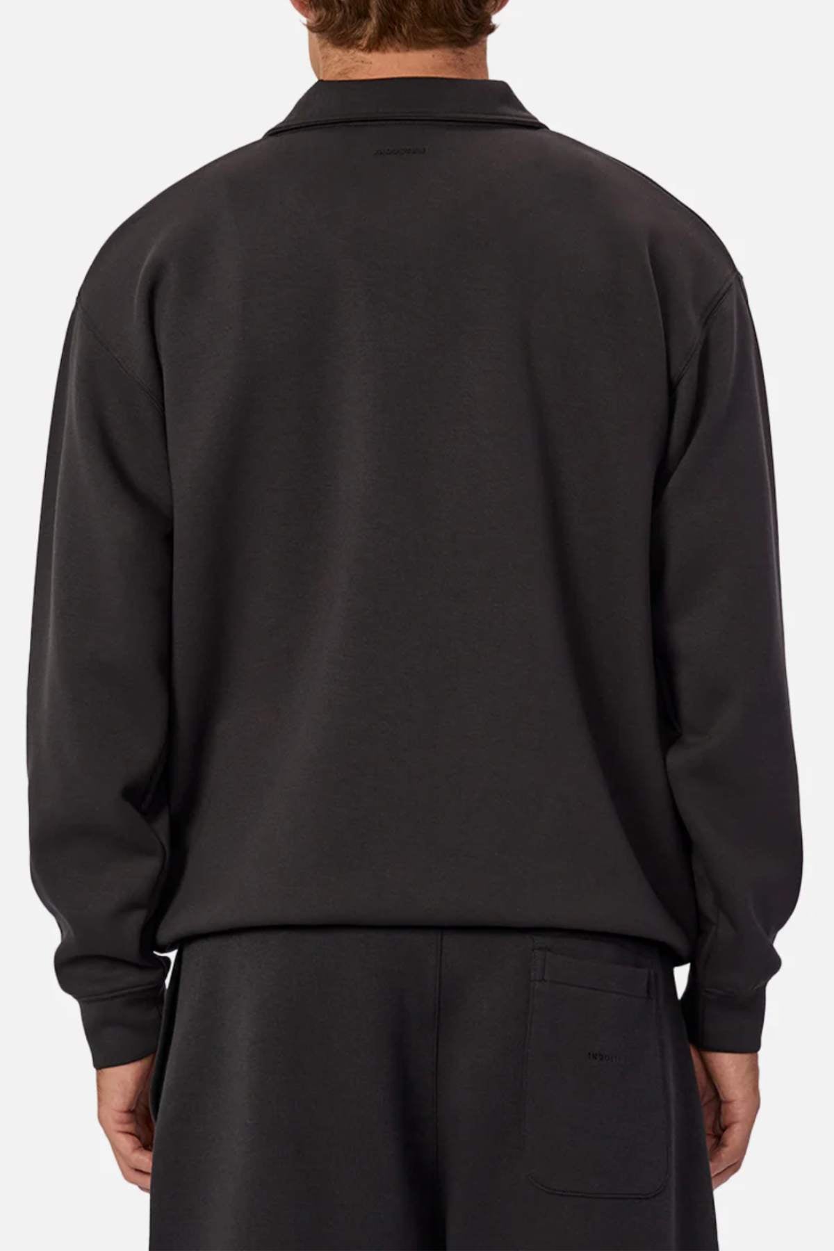 A person is shown from the back against a plain, light background wearing a loose-fitting, long-sleeve Industrie The Tech Staunton Track Top and matching athletic pants.