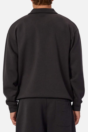 A person is shown from the back against a plain, light background wearing a loose-fitting, long-sleeve Industrie The Tech Staunton Track Top and matching athletic pants.