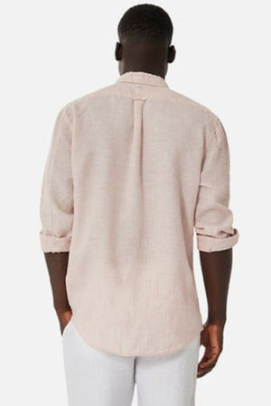 From behind, a person with short hair wears the Industrie The Tennyson Linen Blend Shirt in light pink, highlighting its breezy design. The rolled-up sleeves offer a hint of casual adaptability, perfectly complementing crisp white pants against a simple white background.