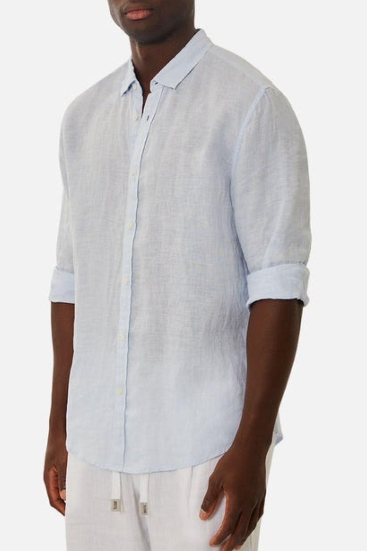 A person in the Industrie The Tennyson Linen Blend Shirt, featuring rolled-up sleeves, and white drawstring pants stands against a plain white background. Their face is not visible.