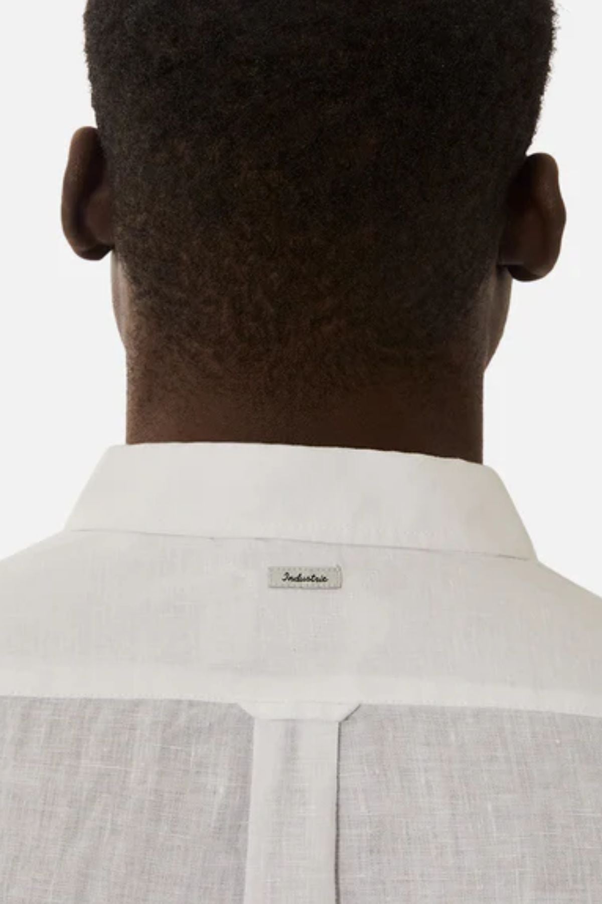 A person with short hair is seen from behind, wearing the Industrie The Tennyson Linen Blend Shirt with a small tag on the back of the collar against a plain white background.