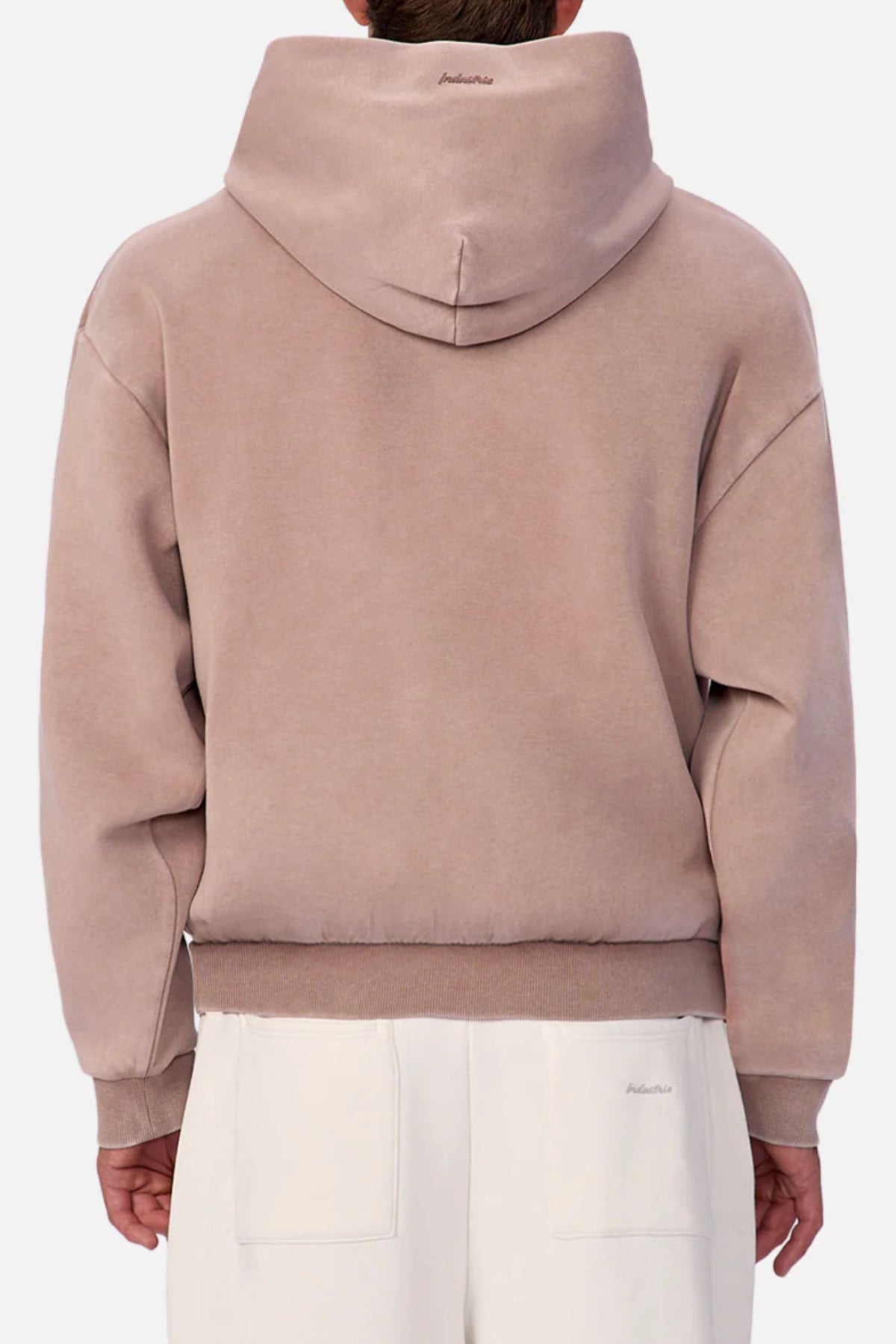 A person wearing the light brown Industrie The Washed Tech Hood with the hood up, seen from the back and paired with off-white pants. The hoodie offers a relaxed fit with ribbed waistband and cuffs, perfect for casual wear.