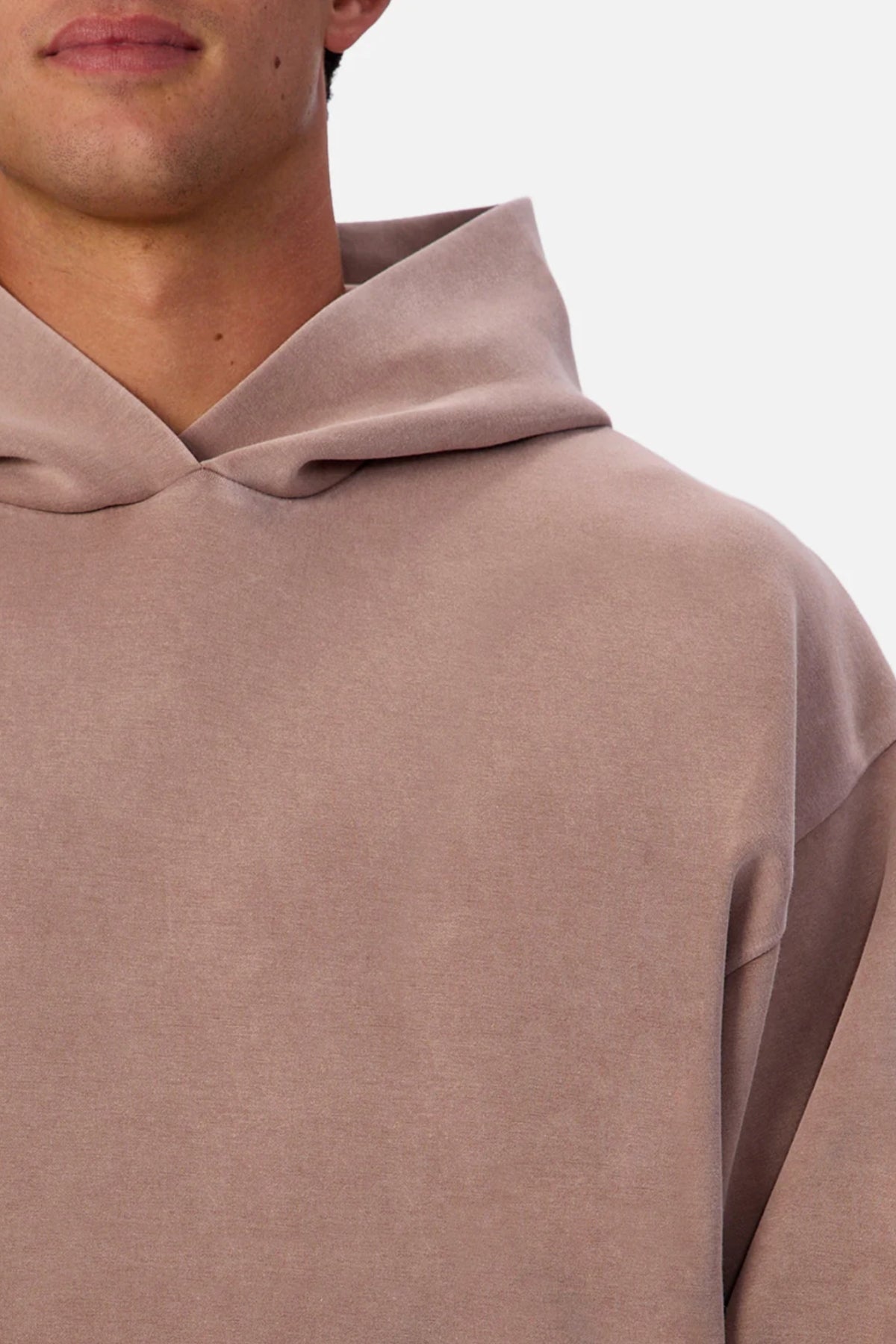 A close-up of a person wearing the Industrie The Washed Tech Hood hoodie in light brown, showing their lower face, neck, and upper torso against a plain white background—ideal casual wear with modern style.