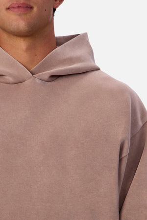A close-up of a person wearing the Industrie The Washed Tech Hood hoodie in light brown, showing their lower face, neck, and upper torso against a plain white background—ideal casual wear with modern style.