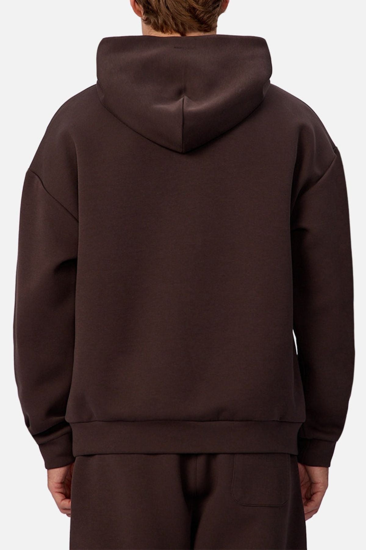 A person wearing an Industrie The Tech Del Sur Hoodie in dark brown, paired with matching pants and viewed from the back against a plain light background, highlights the hoodie's sleek design and breathable fabric.