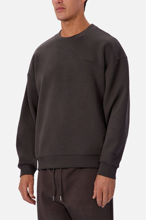 A man wears the Industrie The Tech Del Sur Sweat and matching sweatpants in dark gray against a light background. With its minimalist design and athletic construction, itβs ideal for an active lifestyle.