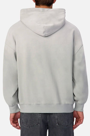 A person is seen from behind wearing the Industrie The Sandblast Hoodie in light gray and dark gray jeans. The 100% cotton hoodie’s hood is down, arms relaxed at their sides, evoking a laid-back vibe against a plain white background.