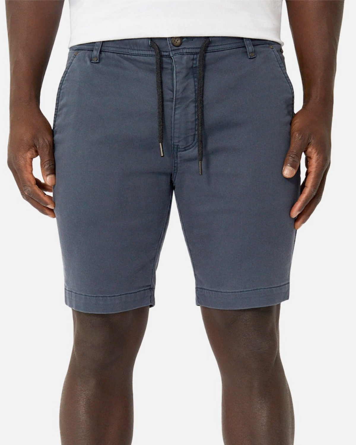 A person models the Industrie The New Drifter Cuba Short in blue, featuring a drawstring, side pockets, and belt loop waist, shown from the waist to above the knees with a white shirt.