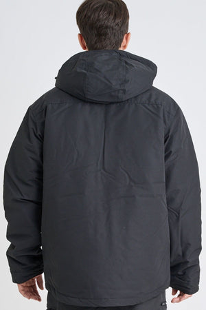 A person is shown from the back wearing the Jetpilot Onsite Pro Jacket, a black padded jacket made from polyester cotton twill, standing against a plain light background.