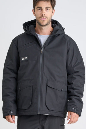 A man faces the camera against a plain light background, wearing a Jetpilot Onsite Pro Jacket made from polyester cotton twill with front pockets and snap buttons.