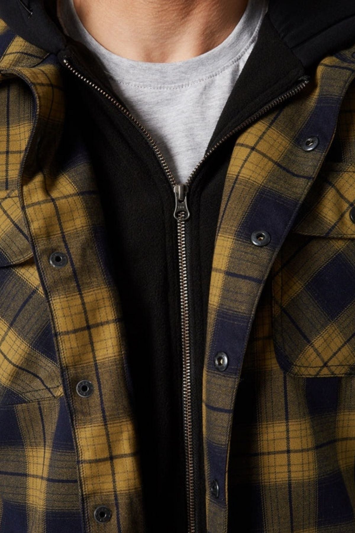 Close-up of a person wearing the Jetpilot Quilted Flannel Jacket over a black zip-up hoodie and light gray t-shirt—only the chest and part of the neck are visible; no face is shown.