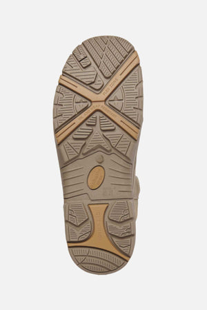 The King Gee Bennu Pro 6 Work Boot features a beige slip-resistant sole with grooves, wavy lines, and crisscrossed shapes. Two tan rubber sections form an X, with embossed wording and symbols on different areas of the sole.