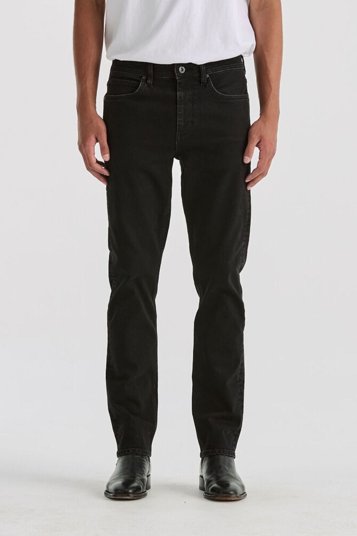 A person, visible from chest down, stands facing forward in a white T-shirt, black shoes, and the Lee Originals L100 Slim Jean against a plain white background, highlighting the timeless style of the jeans.