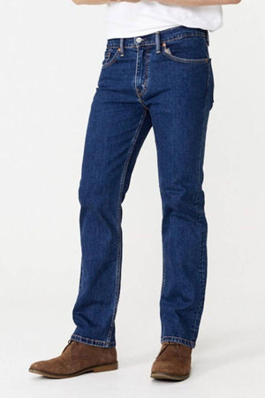 A person is wearing Levis 516 Straight Jean in blue denim, paired with brown suede shoes. The jeans feature a comfortable fit with visible stitching and are fastened with a button and zipper. Made from 100% cotton, the jeans complement the white top that is partially visible in the image.