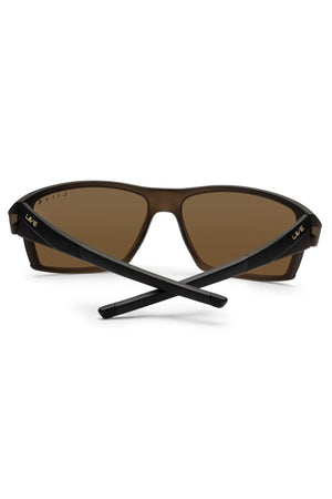Liive X Ignite X Sunglasses with brown lenses and a modern silhouette, black crossed arms, "Liive" branding near the hinges, and slightly mirrored lenses.