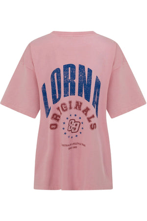 The Lorna Jane Revival Washed Boyfriend T-Shirt is a pink, short-sleeve tee with vintage wash, featuring bold blue “LORNA ORIGINALS 89” and stars on the back. Made from 100% cotton for all-day comfort.