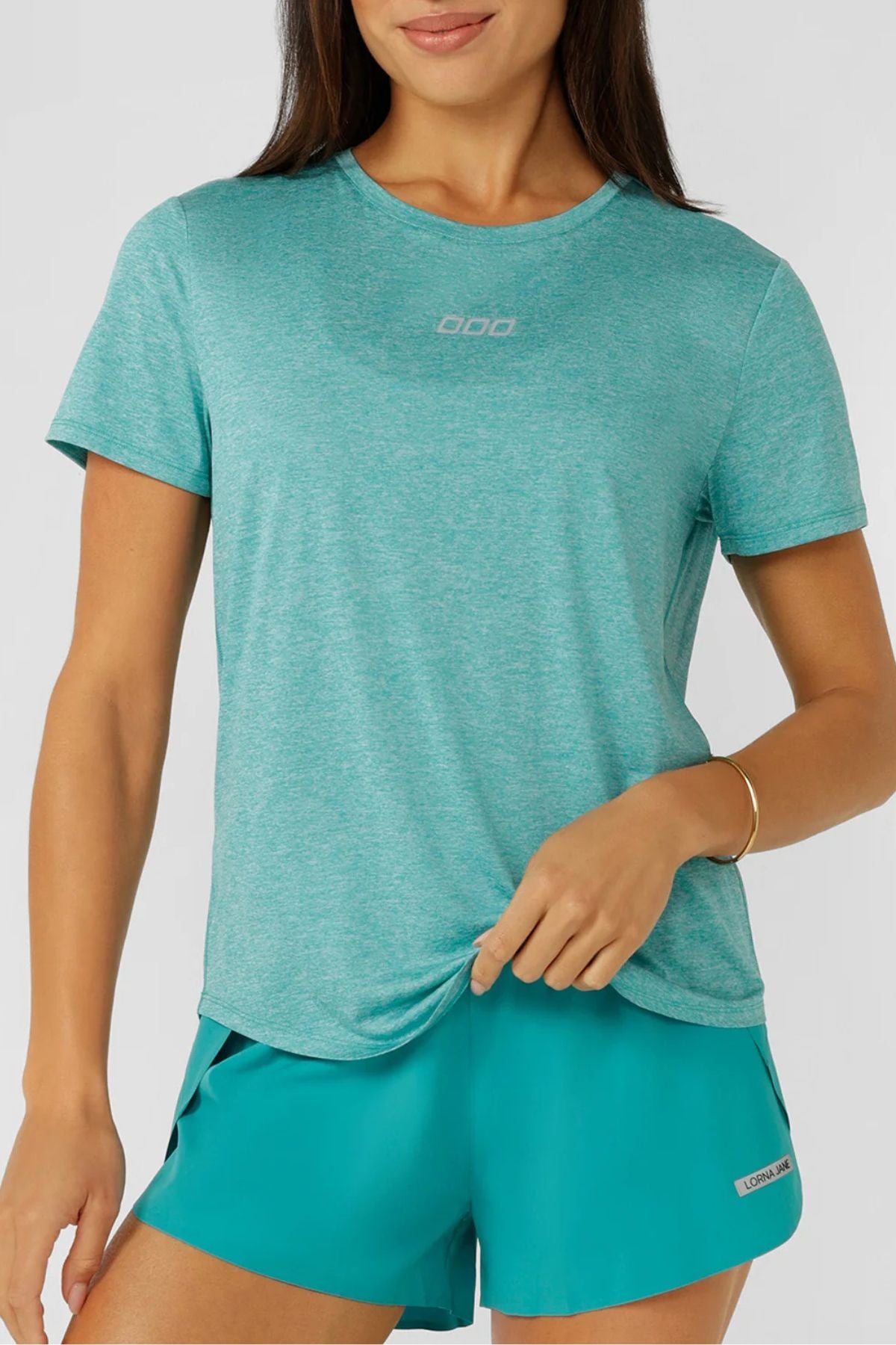 A woman wearing a blue Lorna Jane Amy Dynamic Active T-Shirt made from breathable fabric.