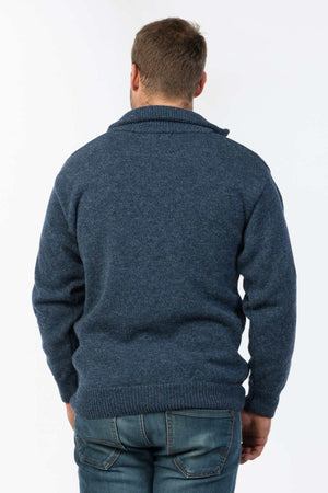 A person with short hair is shown from the back, wearing a blue, long-sleeved MKM North Wester Knitted Jumper and blue jeans. The casual wear ensemble stands out against the plain white background.