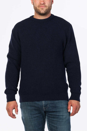 A person wearing the MKM Original Backyard Knit pullover and light blue jeans stands against a plain white background, effortlessly capturing casual wear's essence.